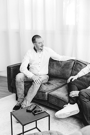 Business-Fotografie in Weingarten im Reportage-Stil: Eine Schwarz-Weiß-Aufnahme zeigt zwei Männer im lockeren Gespräch auf einer Ledercouch während einer IT-Beratung.